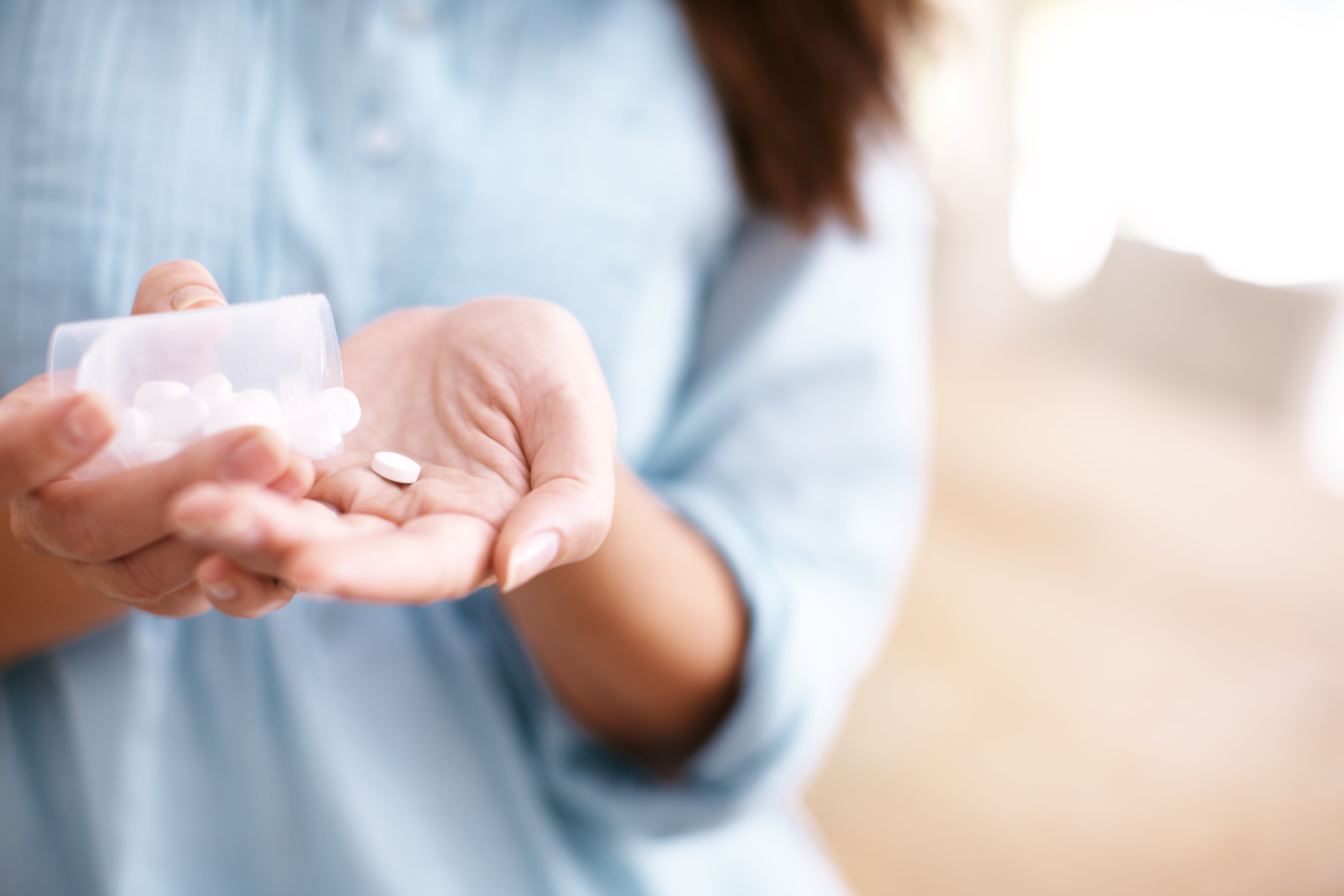 Woman taking a supplement tablet