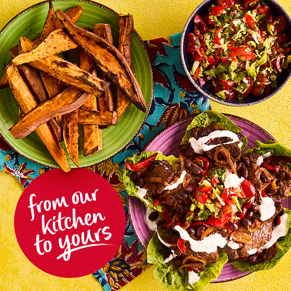 Slimming World Kitchen beef fajitas with sweet potato wedges. In the bottom left corner is a red roundel with the words: From our kitchen to yours.