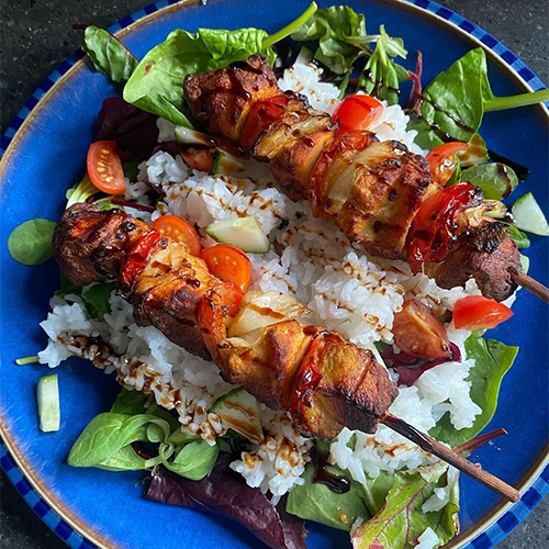 Slimming World member Lesley's BBQ chicken skewers on a bed of white rice and salad leaves
