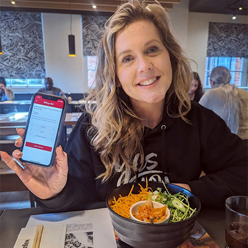 Slimming World member Suzie using the Slimming World app on her phone in Wagamama