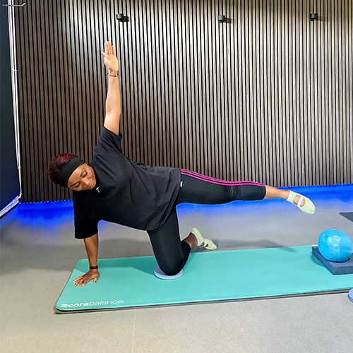 Slimming World member Elsie performing a kneeling side kick on a yoga mat